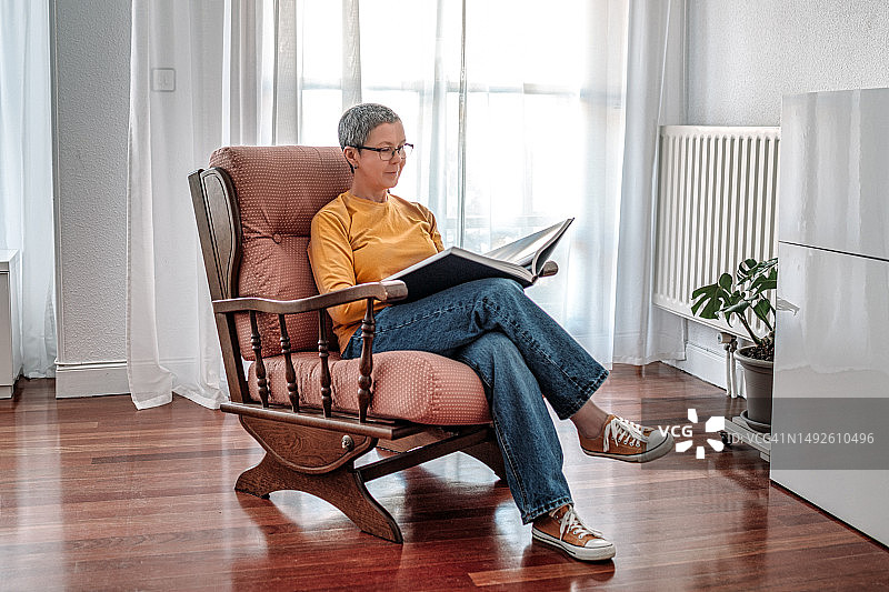 中年女人在椅子上读书图片素材
