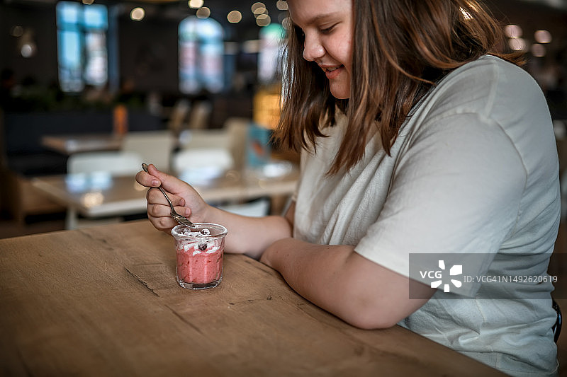 健康美食：青少年享用蔓越莓慕斯，纯素甜点理念图片素材