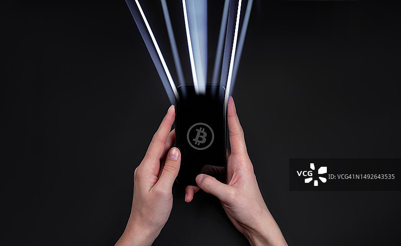 年轻女子用手机转移比特币图片素材