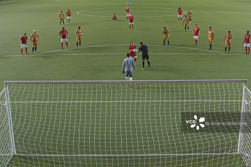 足球裁判给中场球员一个球来执行点球图片素材