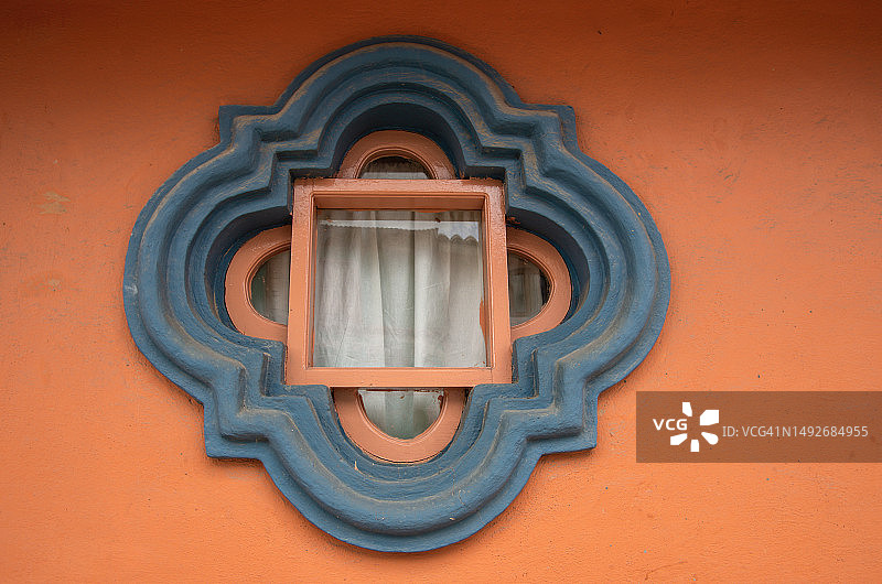 殖民风格房屋上的四叶形玫瑰窗，粉橙色和蓝灰色图片素材