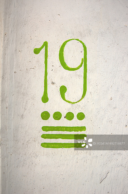 白色灰泥外墙上手绘的房屋街道门牌号19图片素材