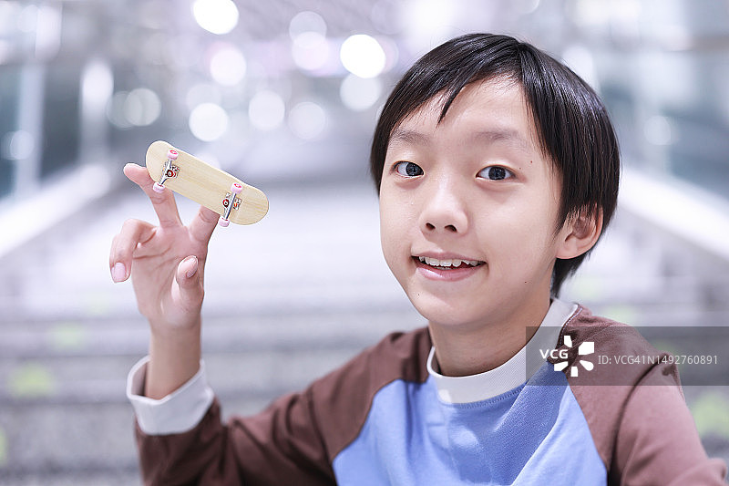 男孩在玩他的手指滑板图片素材