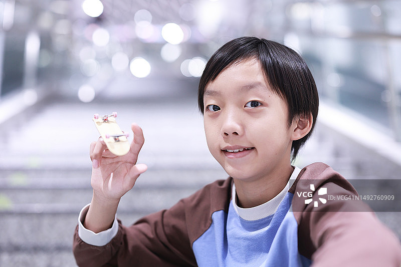 男孩在玩他的手指滑板图片素材