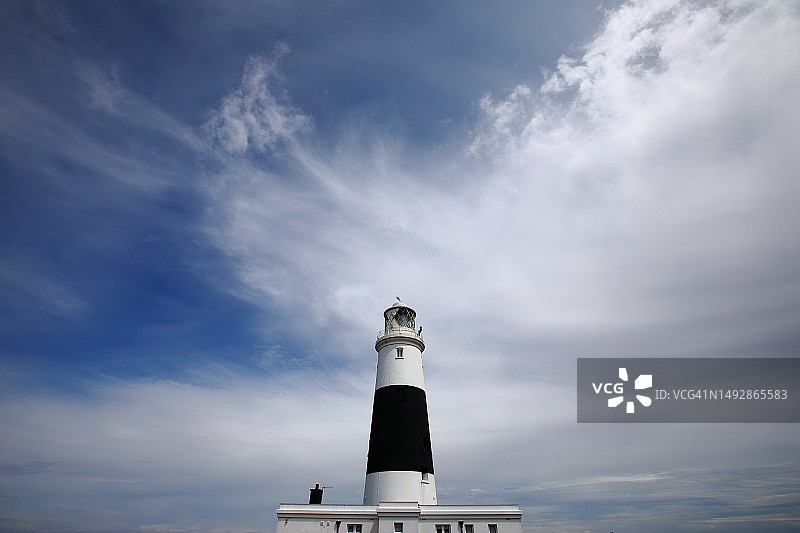 以蓝色多云天空为背景的黑白灯塔图片素材