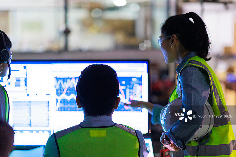 一群亚洲工程师在夜班制造车间使用电脑工作图片素材