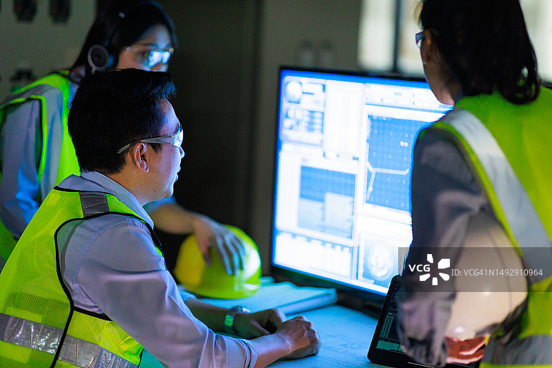 一群亚洲工程师在夜班制造车间使用电脑工作图片素材