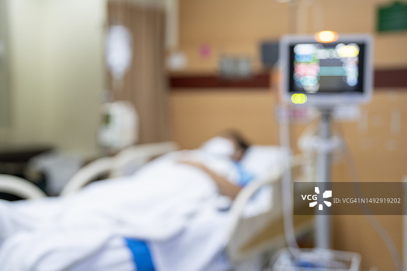 医院病床上的病人，医疗模糊的白色病房内部背景，有护理或医疗康复治疗图片素材