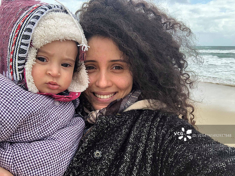 海滩上微笑的母女肖像，突尼斯图片素材