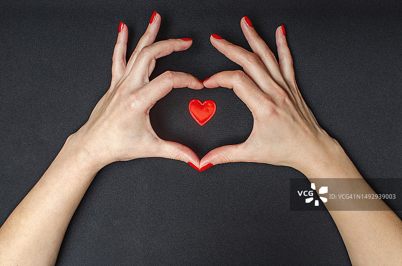 女子手持心形玫瑰花瓣，白色背景图片素材