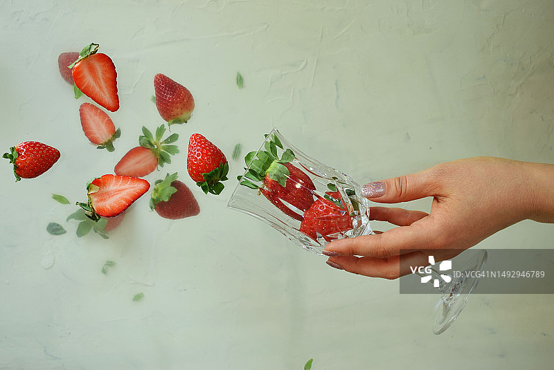 新鲜红色草莓从玻璃杯中掉落图片素材
