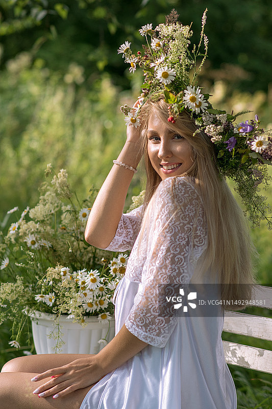 年轻女子坐在花旁的椅子上，俄罗斯克麦罗沃州图片素材