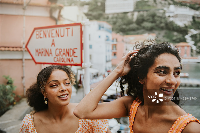 两名女人站在意大利索伦托著名的玛丽娜格兰德手绘标牌旁图片素材