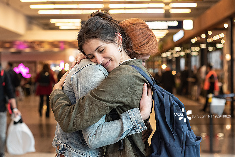 年轻女人在机场拥抱她的朋友图片素材