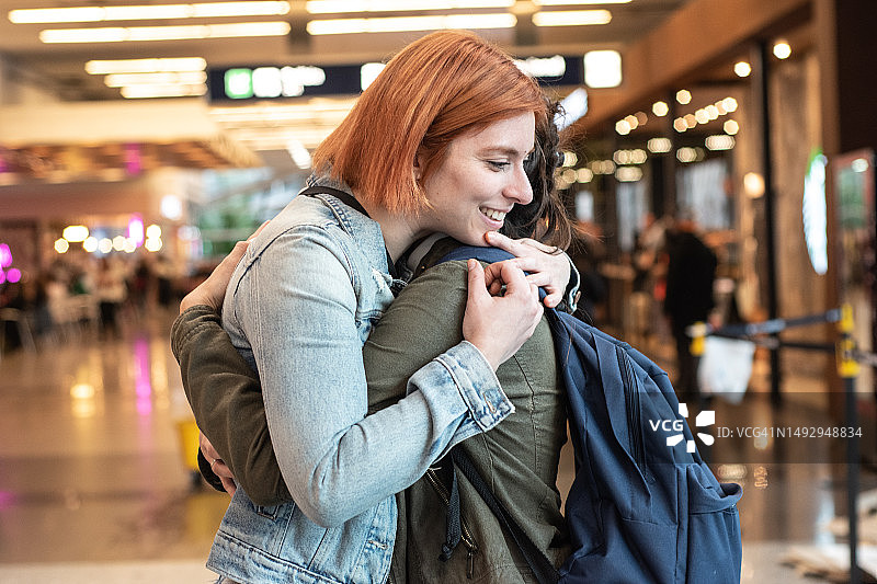 年轻女人在机场拥抱她的朋友图片素材