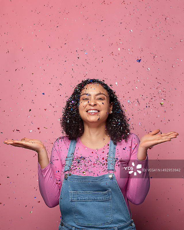 在粉色纸屑中的年轻女子肖像，美国佛罗里达州基西米图片素材