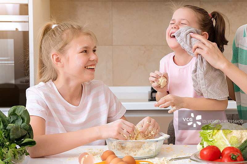 幸福的一家：孩子们在厨房准备面团，烘烤饼干图片素材