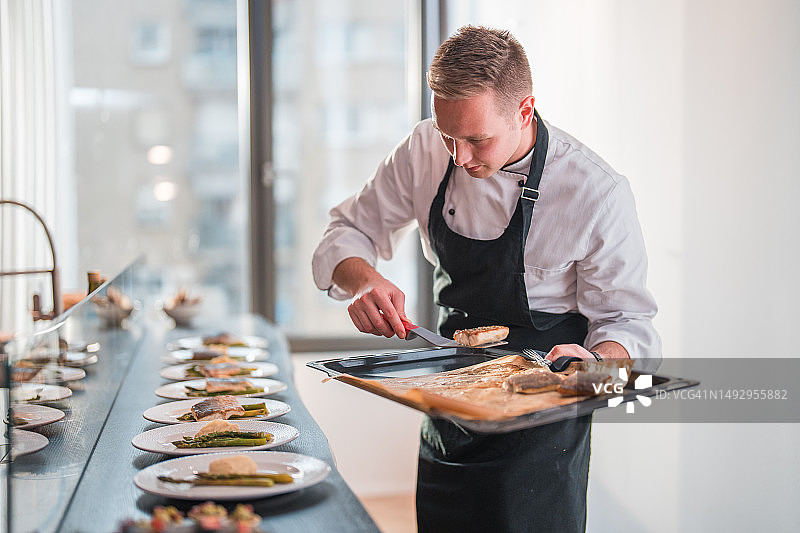 在现代厨房准备食物的白人私人厨师图片素材