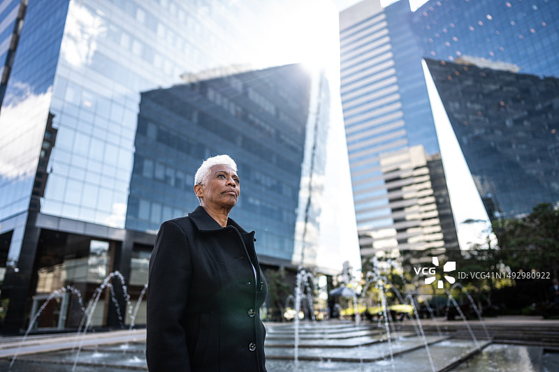户外沉思的老年女商人图片素材