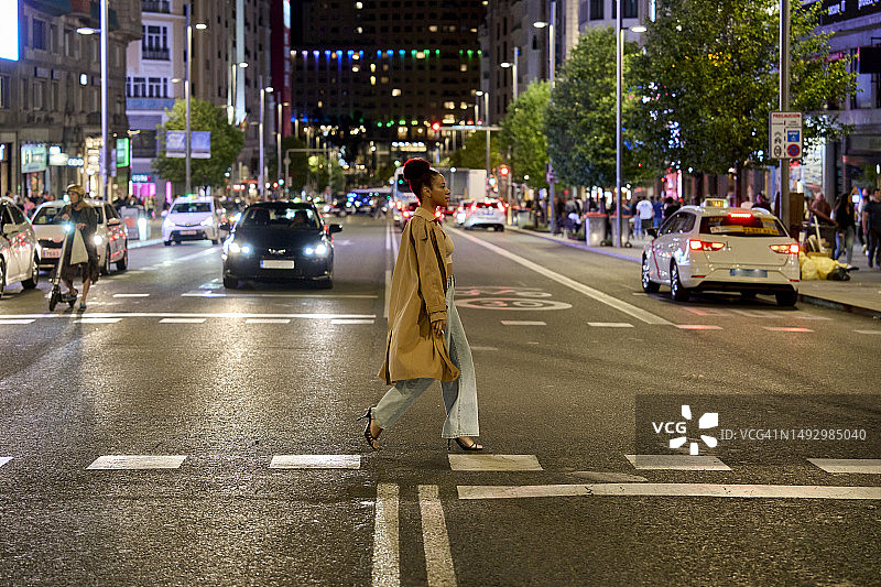 年轻女子夜间过马路图片素材