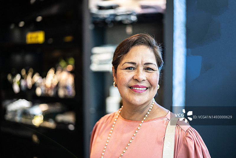 在服装店的中年妇女肖像——店主或顾客图片素材