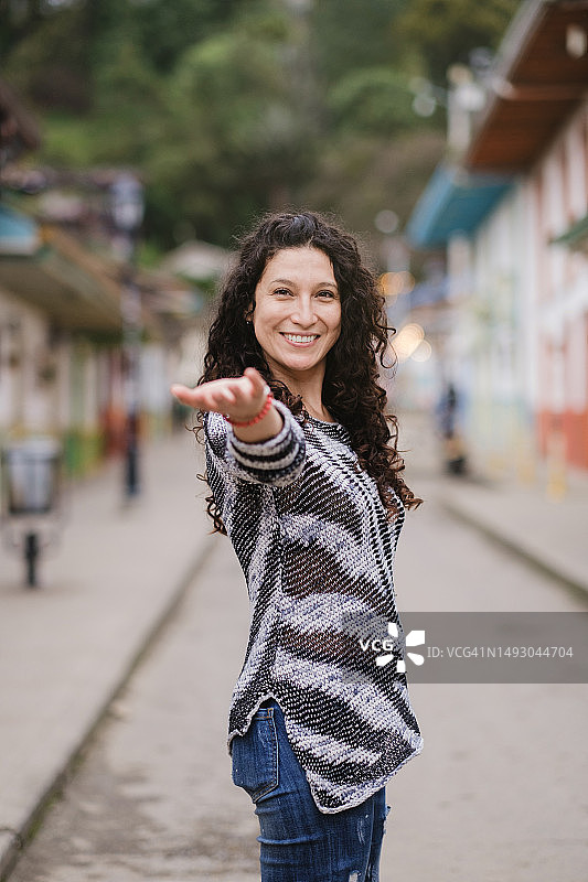 在城市街道上伸出手邀请的女人图片素材