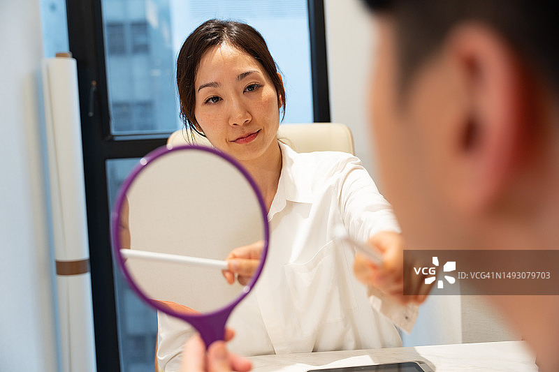 亚洲美容顾问/美容医生与亚洲男性客户进行咨询图片素材