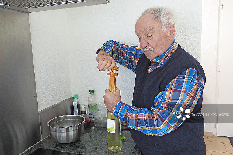 打开葡萄酒瓶的年长男人图片素材