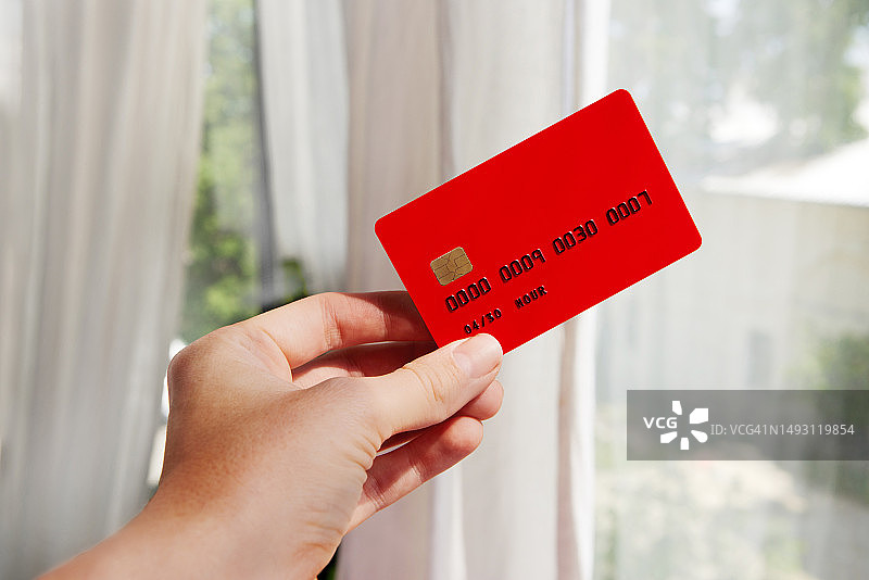 手持信用卡，背景虚化图片素材