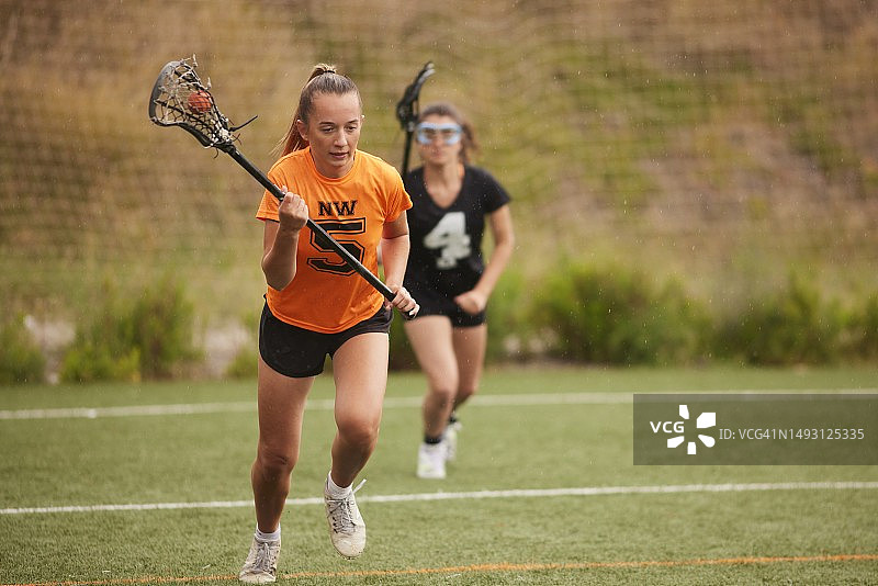 奋力冲刺：长曲棍球运动员在对手的追逐中快速奔跑图片素材