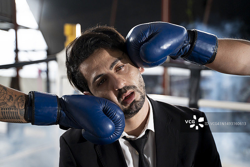 拳击台上被两个对手击中的商人图片素材