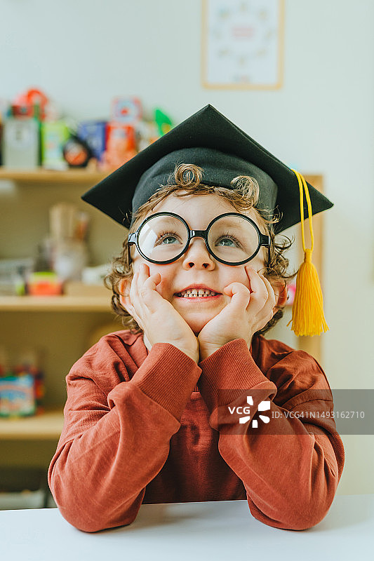 戴着毕业帽和眼镜向上看的男孩肖像图片素材