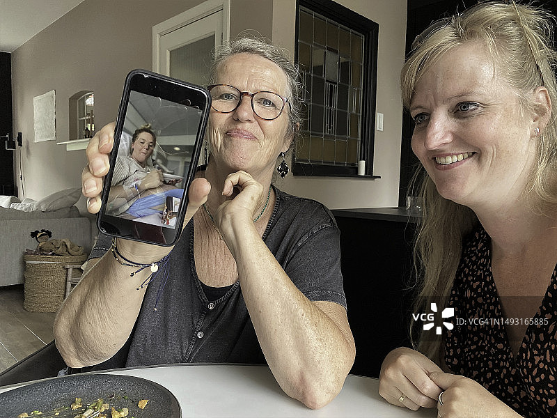 母亲和妹妹与生双胞胎的女儿聊天图片素材