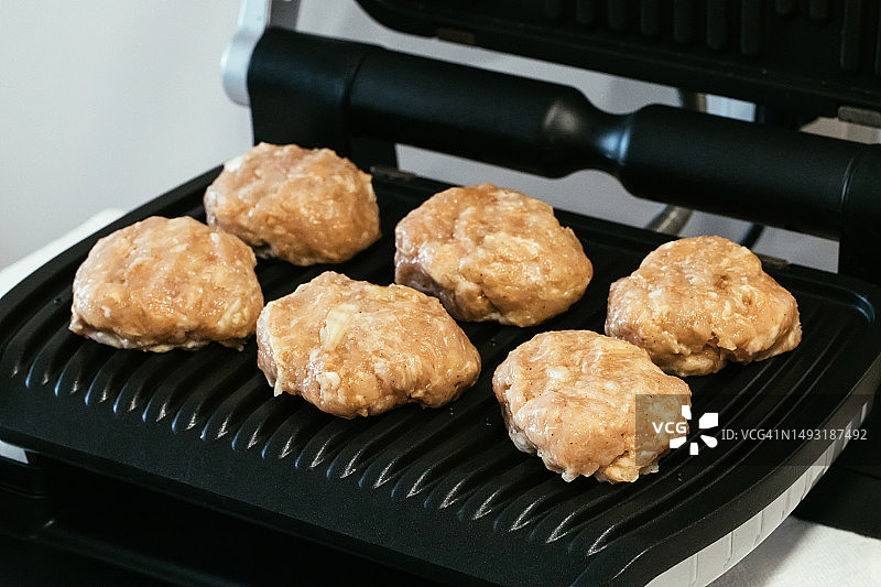家用电烤架上的生鸡肉片图片素材