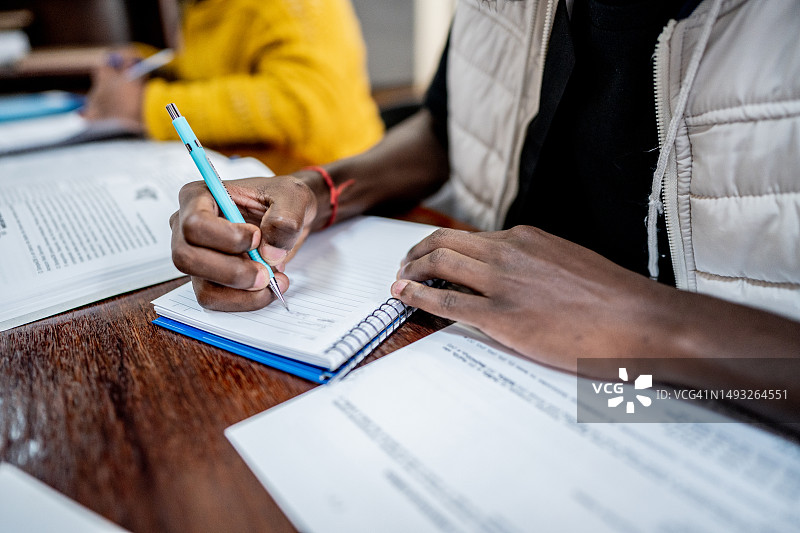 男子在图书馆的笔记本上写作图片素材