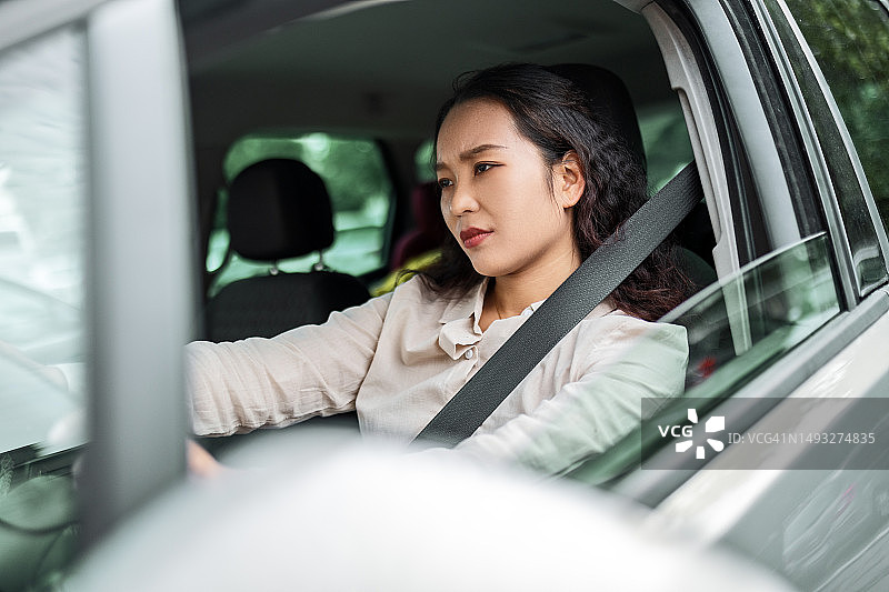 开车时表情严肃的亚洲女商人图片素材