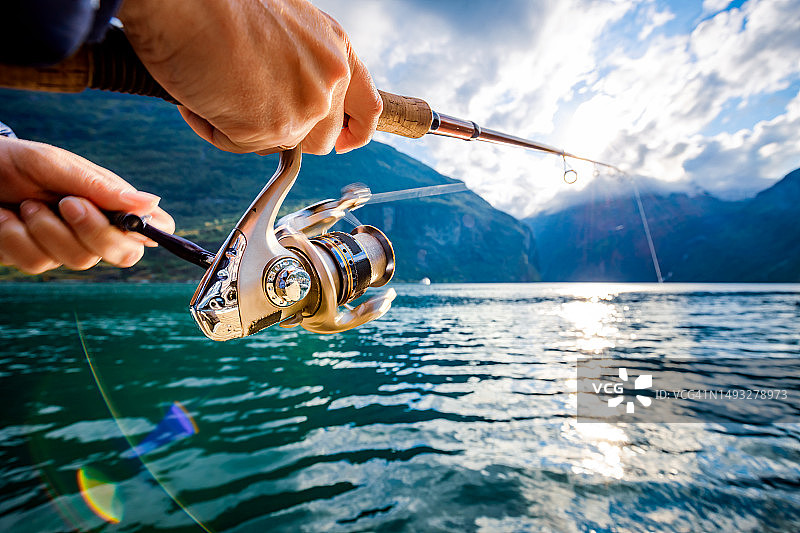 男子在挪威湖中钓鱼图片素材