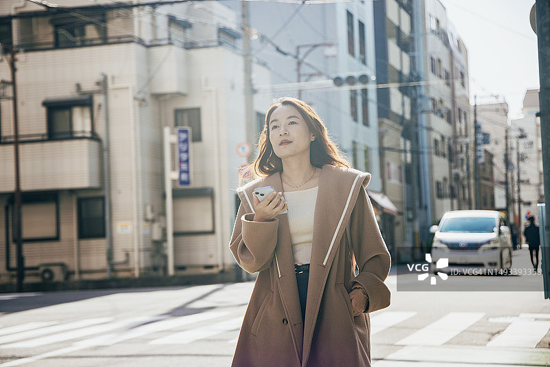 在日本大阪使用智能手机应用程序导航的亚洲女性图片素材