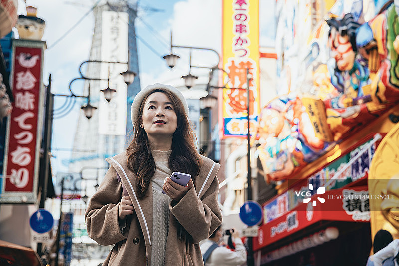 一位亚洲女性在日本大阪观光，在通天阁前的商店街漫步图片素材
