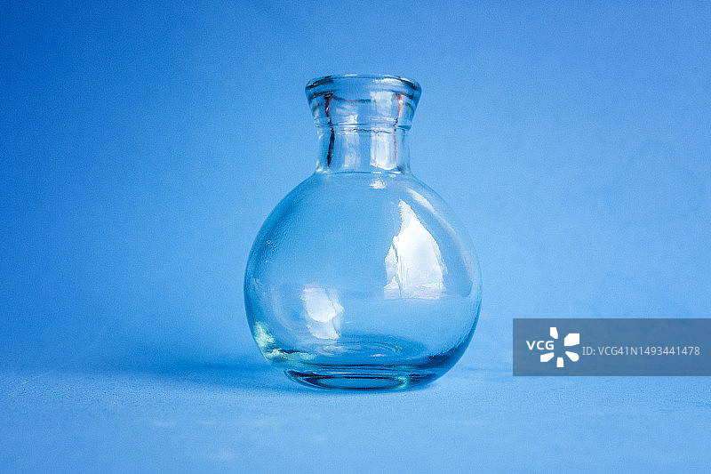 蓝色背景上的空玻璃瓶图片素材
