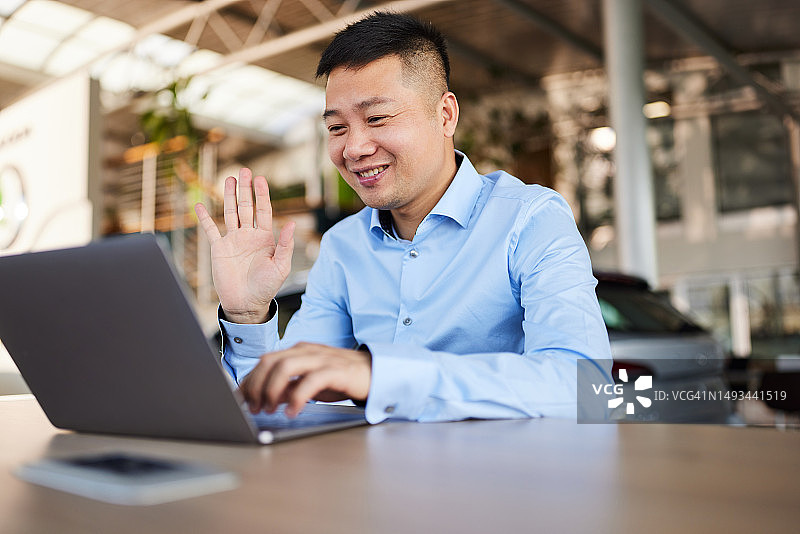 展厅内汽车销售员进行视频通话图片素材