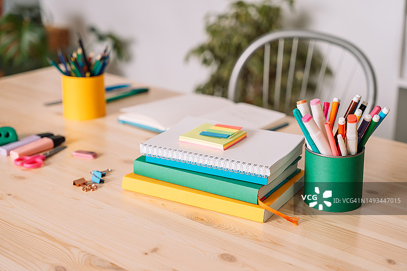 白色墙壁前的学校课桌与学习用品图片素材