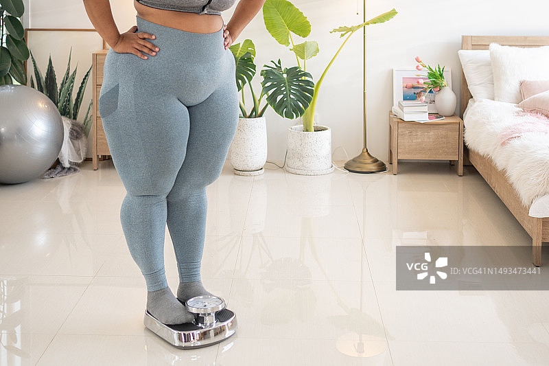 站在体重秤上的超重妇女图片素材