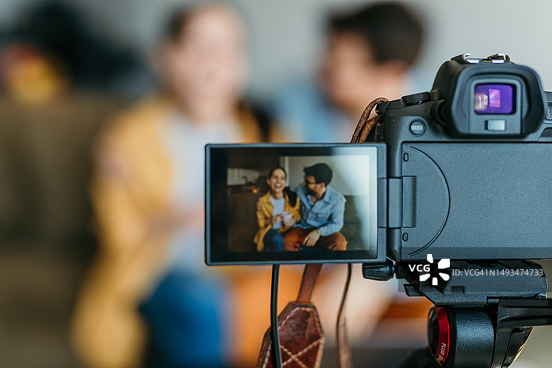 一对快乐的情侣博主正在录制股票交易视频教程图片素材