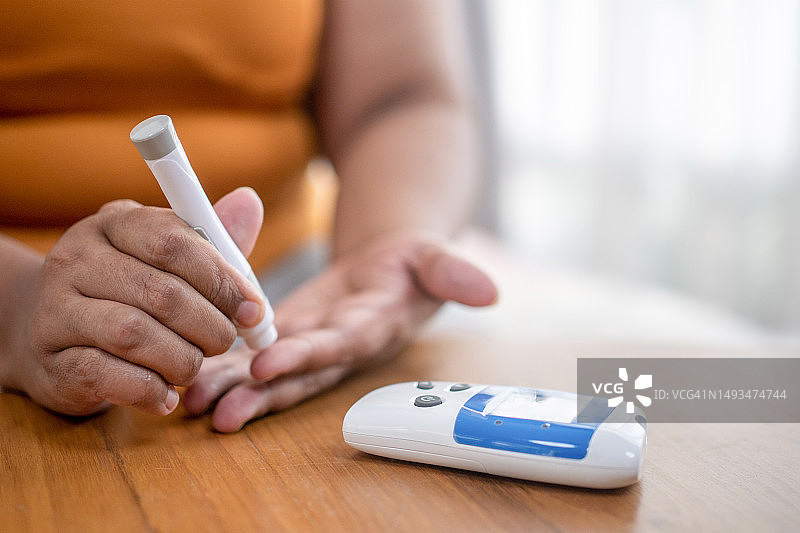 用便携式血糖仪进行血糖手指采血测试图片素材