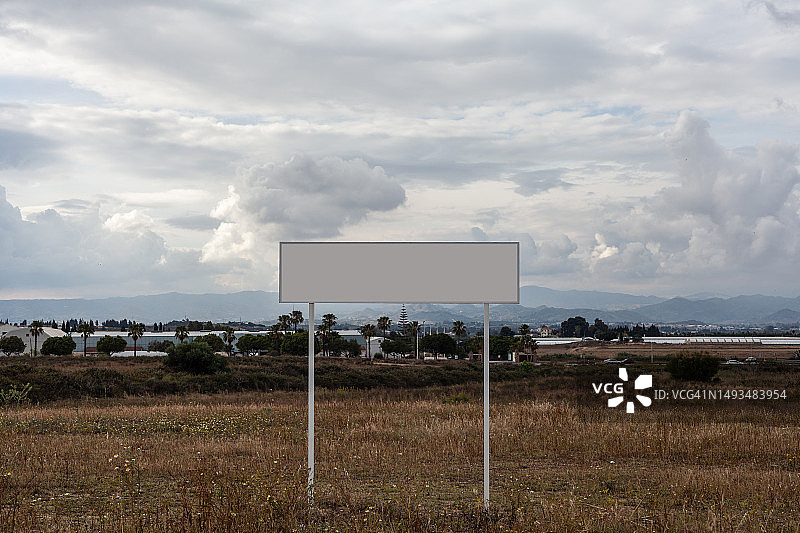放置在田野中间的白色广告牌图片素材