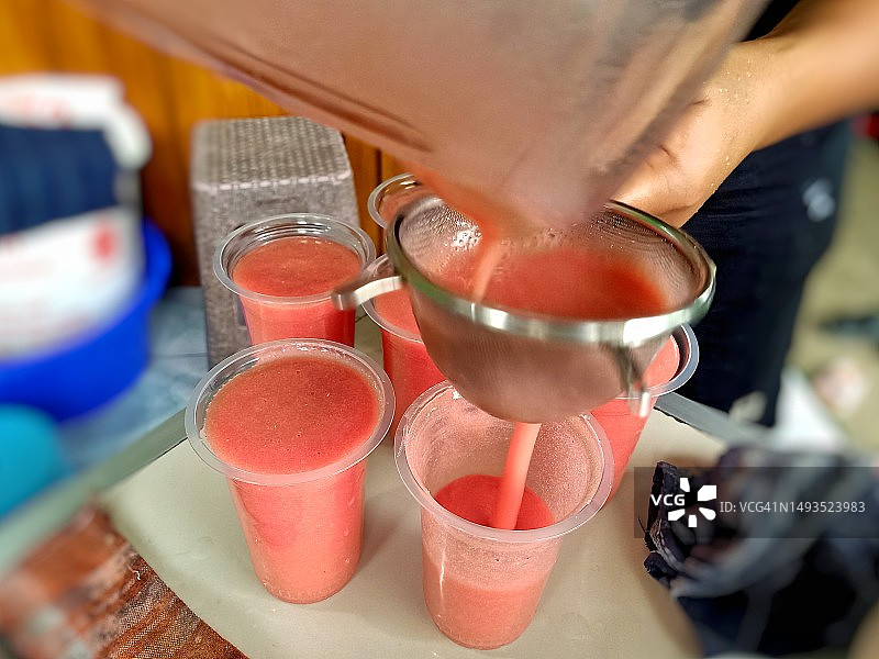 将番石榴汁倒入塑料杯中图片素材