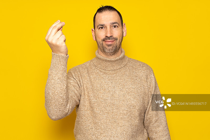 有胡子的拉丁裔男人穿着高领毛衣做手势图片素材