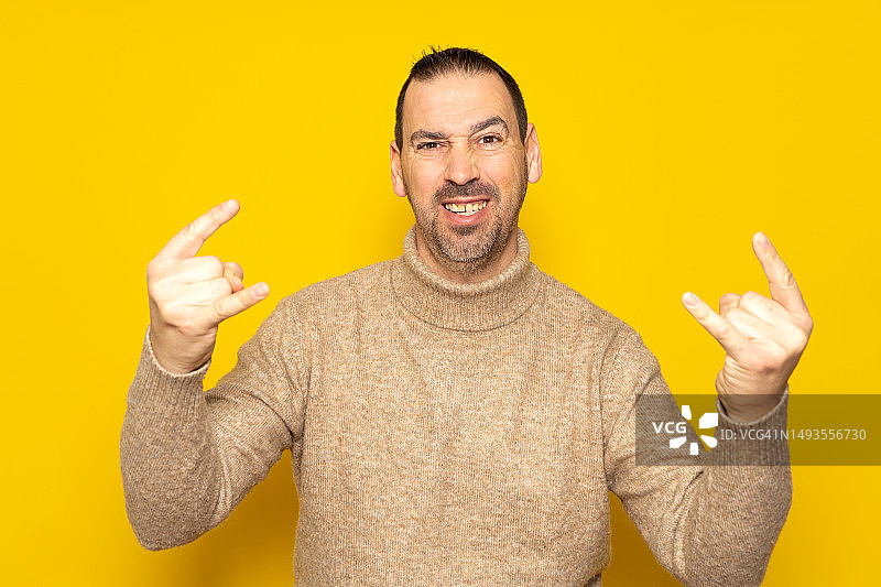 兴奋的时髦男人穿着米色高领毛衣照片图片素材