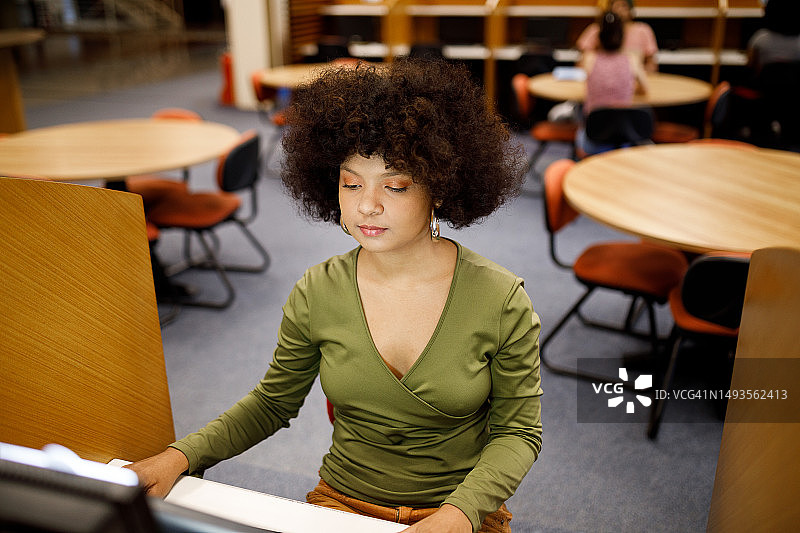 在校园图书馆独自学习的大学生图片素材